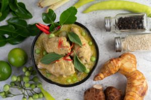 Chicken green curry in a bowl .