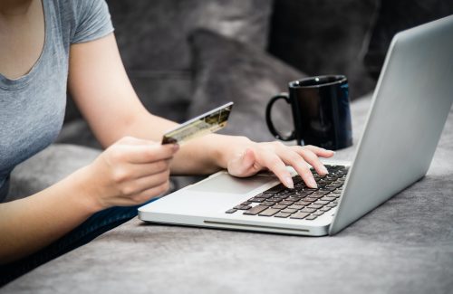 Woman holding credit card shopping online